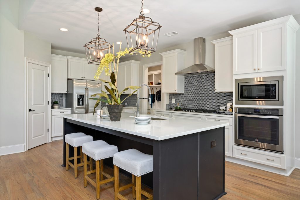 modern kitchen with black kitchen island and black tile backsplash for Dream Home, Dream Loan program