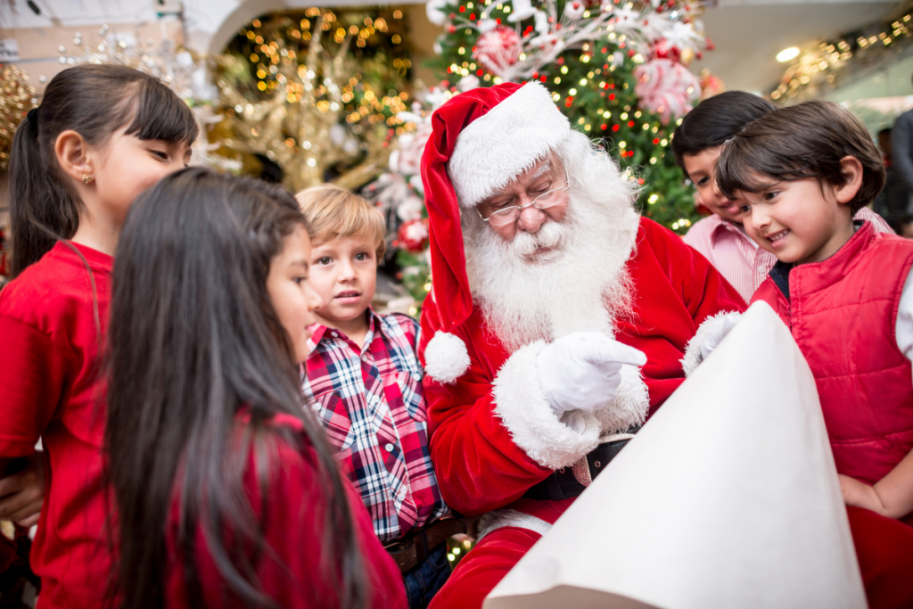 children with santa looking at nice list