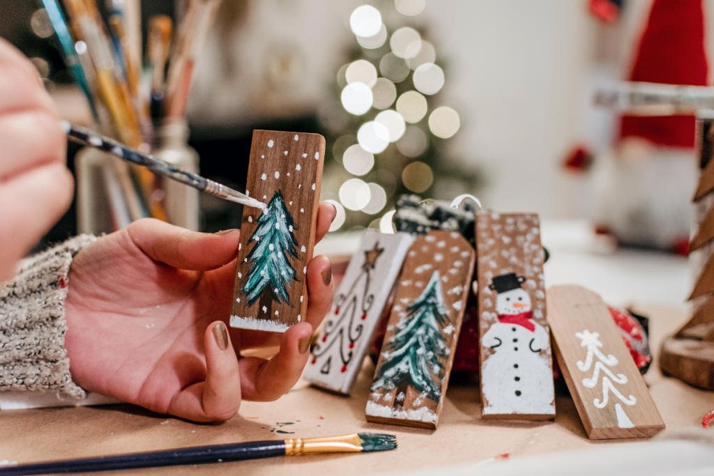 person painting christmas ornaments